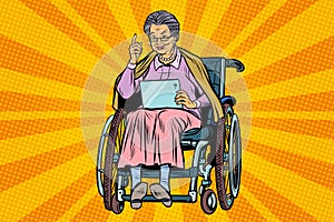 Elderly woman disabled person in a wheelchair, gadget tablet