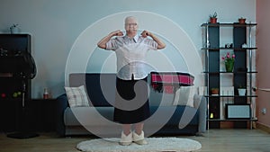An elderly woman does exercises while in the room