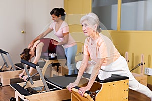 Elderly woman doing exercises on wunda chair in pilates studio
