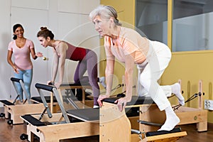 Elderly woman doing exercises on wunda chair in pilates studio
