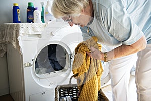 Elderly woman doing a laundry