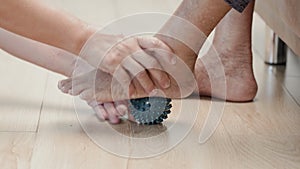 Elderly woman doing rubber ball for exercise fingers, palm ,hand and foot muscle with caregiver take care