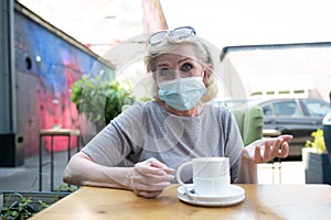 Elderly woman drink coffee or tea drink at the outdoors cafe