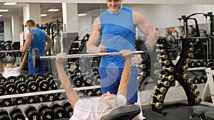 elderly woman, eldest is engaged in sports in gym. Muscles swing barbell. Retired concept, healthy lifestyle, indoor