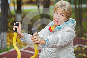 Elderly woman is engages in sport simulator in photo
