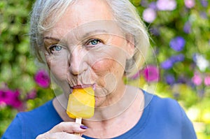 Elderly woman enjoying a refreshing iced lolly