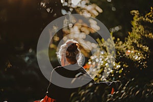 Elderly woman enjoying serene moment in lush garden