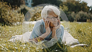 Elderly woman enjoying the sunny autumn day in the park
