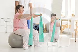 Elderly woman exercising shoulders muscles