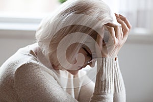 Elderly woman feeling unwell suffering from pain or dizziness photo