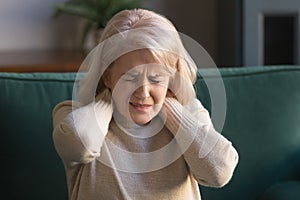 Elderly woman feels unhealthy massaging neck relieving pinched nerve