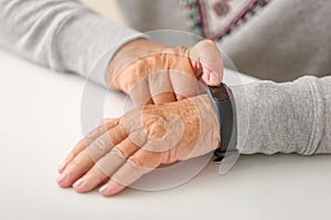 Elderly woman with fitness band checking her pulse, closeup