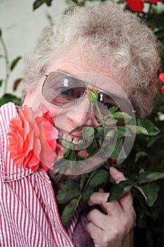 Elderly woman with flower stem in mouth