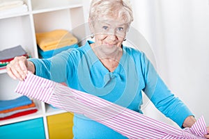 Elderly woman during folding laundry