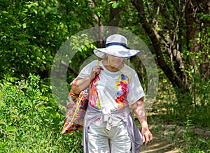 elderly woman in a forest with a backpack.Hiking.