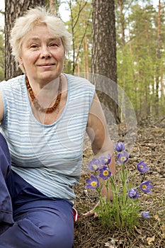 An elderly woman in the forest springtime