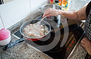 Elderly woman frying meatballs