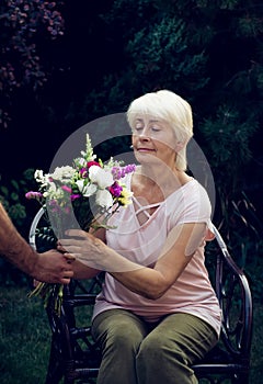 Elderly woman get a beautiful bouquet of field flowers.