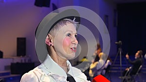 Elderly woman giving interview to journalist and smiling, standing at tv studio during show spbd.