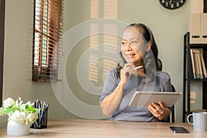 Elderly woman with glasses looking at digital tablet Concept of education, modern technology,