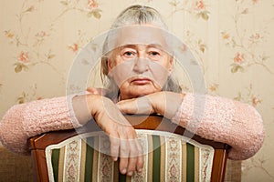 Elderly woman grieves at home.