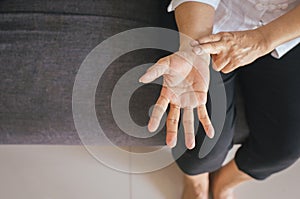 Elderly woman hand checking her pulse with two fingers on wrist