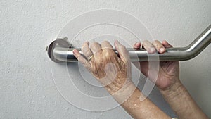 Elderly woman hand holding on handrail for support