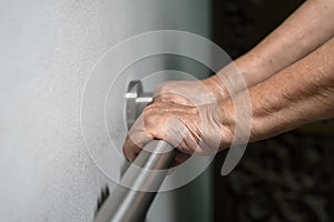 Elderly woman hand holding on handrail for walking