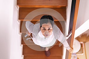 Elderly woman hands holding sticks while walking up stair at home