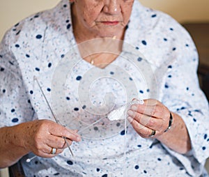 Elderly woman hands knitting at home