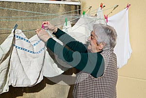 Elderly woman hanging out the washing