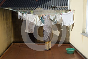 Elderly woman hanging out the washing