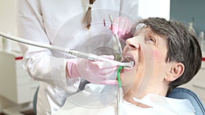 Elderly woman having her teeth fixed at dentist's