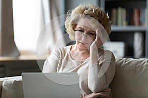 Elderly woman having troubles with laptop usage