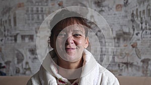 Elderly woman having a video chat to the camera smiling and talking happily indoors in a cozy apartment