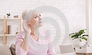 Elderly woman with hearing loss at home