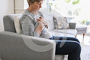 Elderly woman with heart pain holding her chest