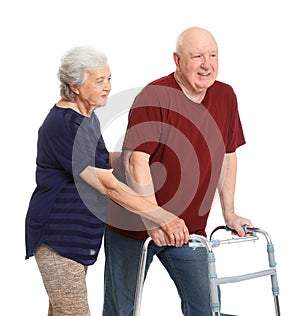 Elderly woman helping her husband with walking frame