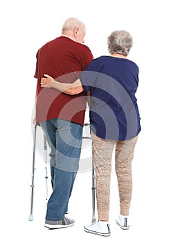 Elderly woman helping her husband with walking frame on white