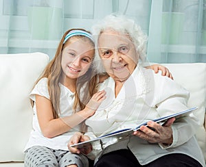 Elderly woman and her granddaughter with book