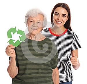 Elderly woman and her granddaughter with recycling symbols on background