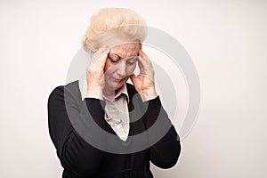 Elderly woman hold hands on her sore head