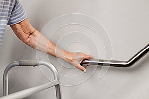 Elderly woman holding on handrail for safety steps