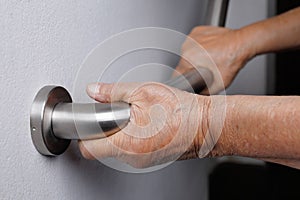 Elderly woman holding on handrail for safety steps