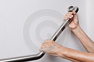 Elderly woman holding on handrail for safety steps