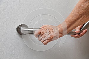 Elderly woman holding on handrail for safety walk steps