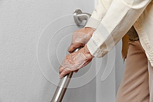 Elderly woman holding on handrail for safety walk steps