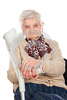 Elderly woman holding her crutch