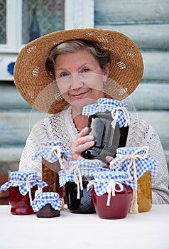 Elderly woman holding jar of homemade jam