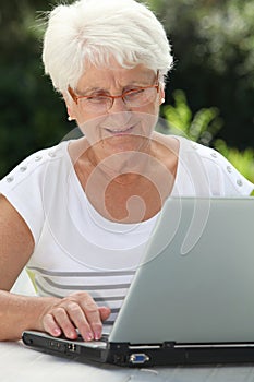 Elderly woman at home with computer